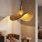 Elva wicker lampshade lit, casting a soft off centre glow