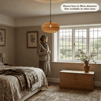 Isla wicker lampshade hanging in a cosy British bedroom with a woman standing next to the window