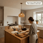 Woman preparing food beneath the Mira wicker lampshade in a bright kitchen