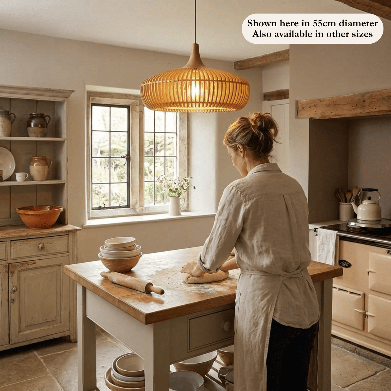 The Rowan wooden lampshade in a bright kitchen with a woman cooking