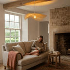 Our Talia bamboo ceiling lampshade in a bright living room with a woman reading a book