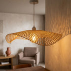 Talia bamboo lampshade lit, casting a warm golden glow