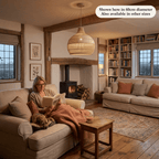 Vera rattan lampshade hanging above a couch with a woman reading with her dog beside.